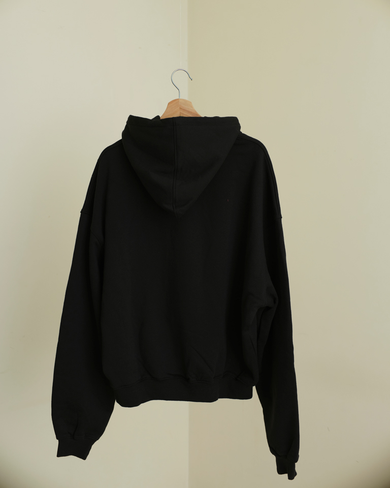 Black oversized hoodie with bold pink chenille graffiti patch and relaxed fit from Now + Thenn.