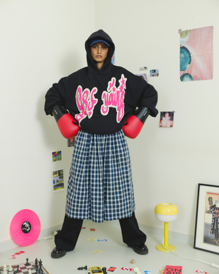 Black oversized hoodie with bold pink chenille graffiti patch and relaxed fit from Now + Thenn.