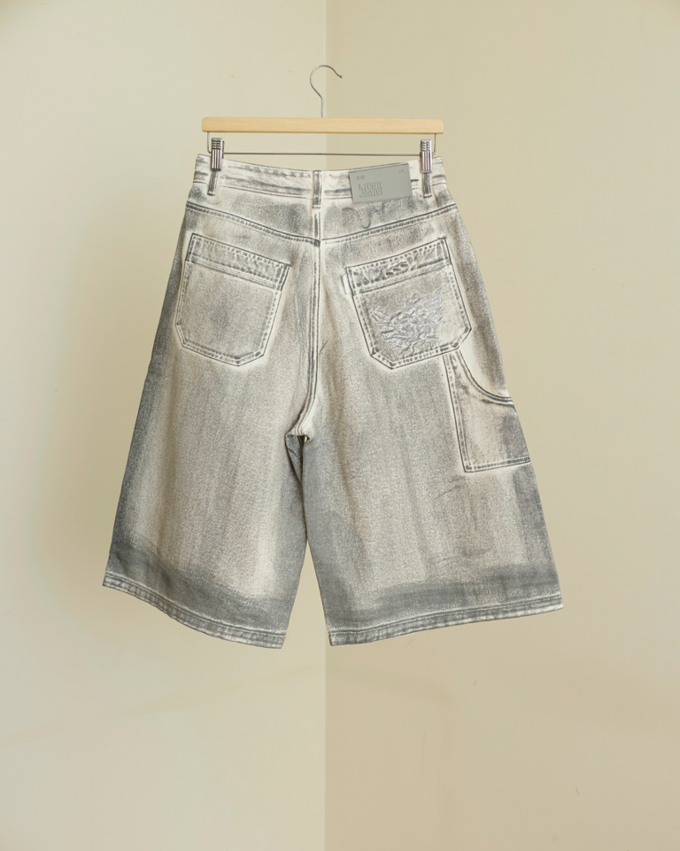 Unisex light gray washed denim carpenter shorts with knee-length wide legs, slanted pockets, and dragon embroidery on the back pocket