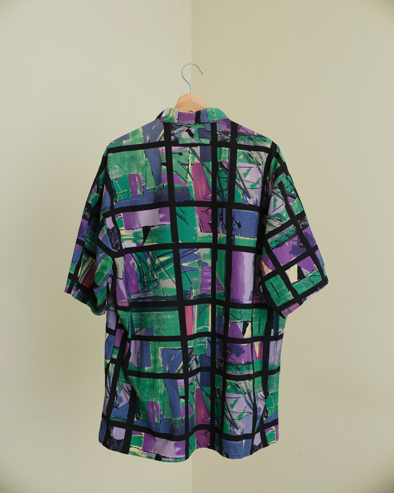 Unisex oversized shirt with geometric abstract print in green, purple, and blue, featuring bold grid pattern and relaxed fit by Now + Thenn.