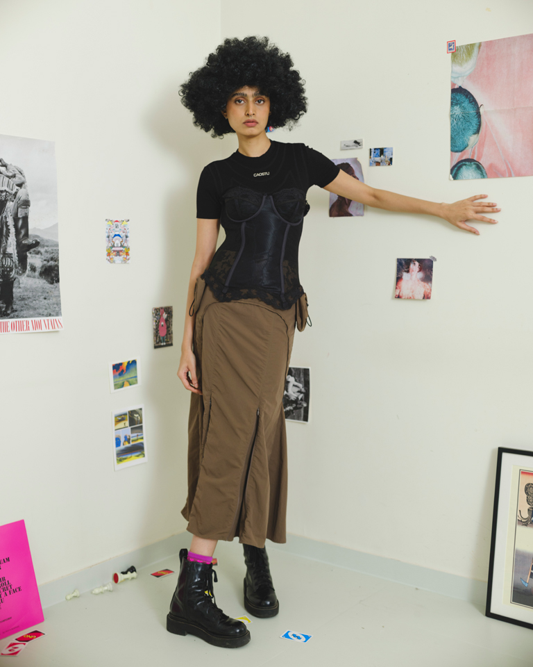 Brown panelled midi skirt with detachable utility pockets and zipper slit detail, structured modern silhouette by Now + Thenn.