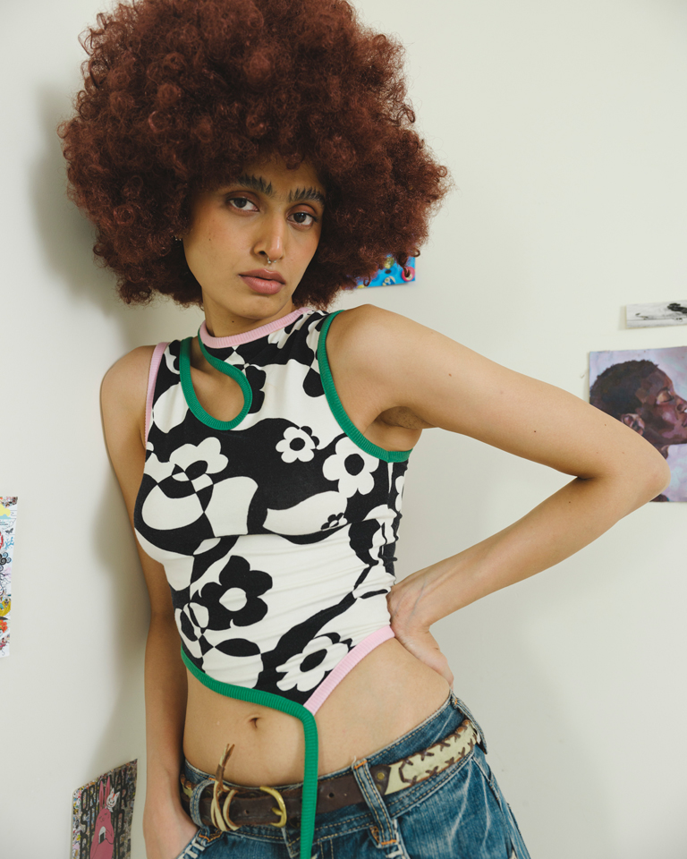 Black and white floral asymmetric crop top with green contrast piping, cutout neckline and tie detail, fitted silhouette by Now + Thenn.