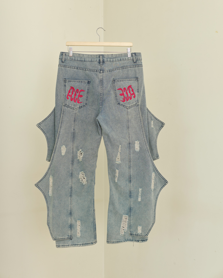 Light wash wing panel distressed denim jeans with sculptural side extensions and wide-leg fit by Now + Thenn.