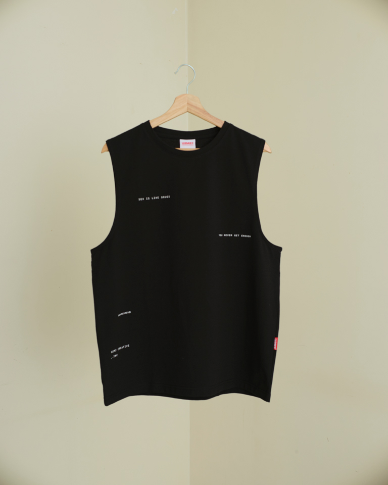 Black sleeveless tank top with “Sex Is Like Drugs” minimal text print and relaxed silhouette by Now + Thenn.