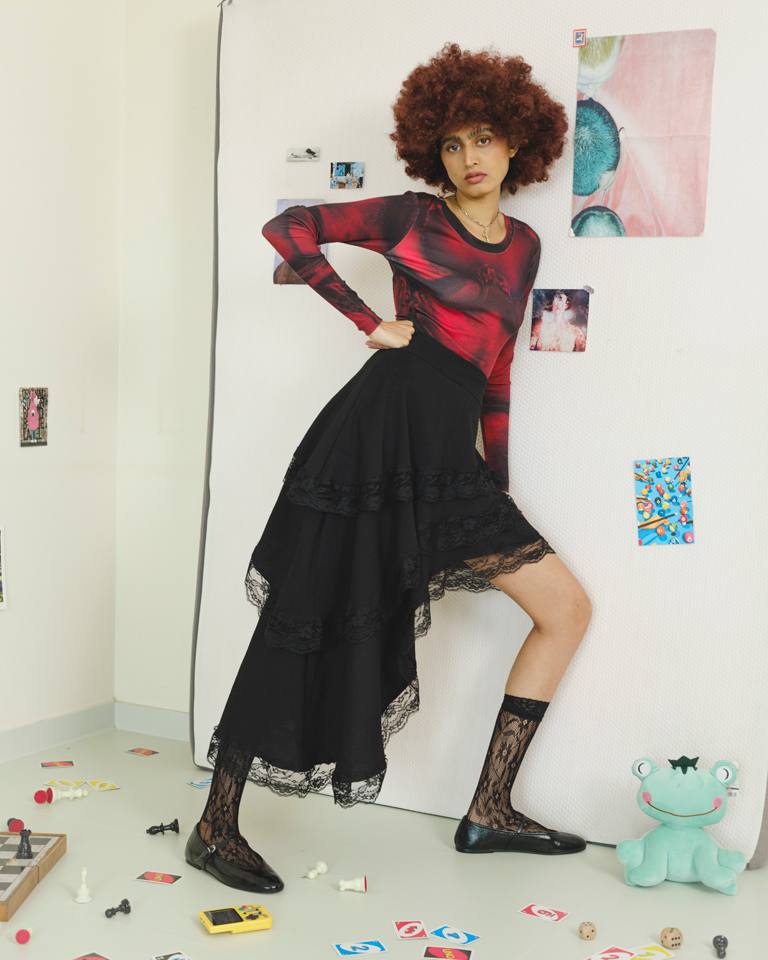 Black asymmetric high-low skirt with layered lace trim panels and fluid draped silhouette by Now + Thenn
