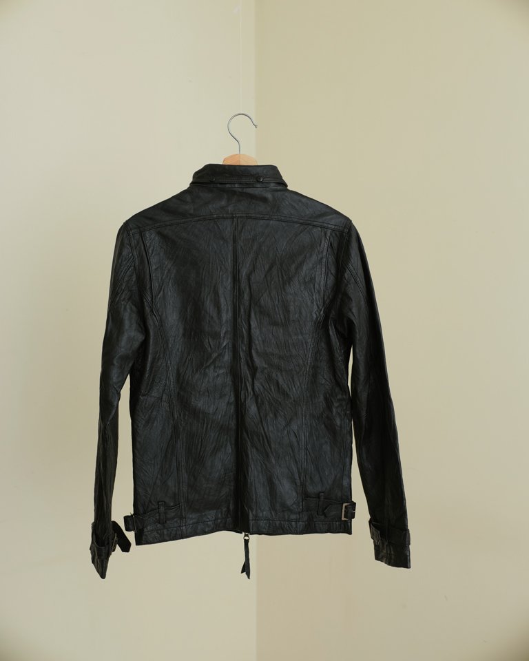 Black leather biker jacket with zip front, utility pockets and slim fit silhouette by Now + Thenn.