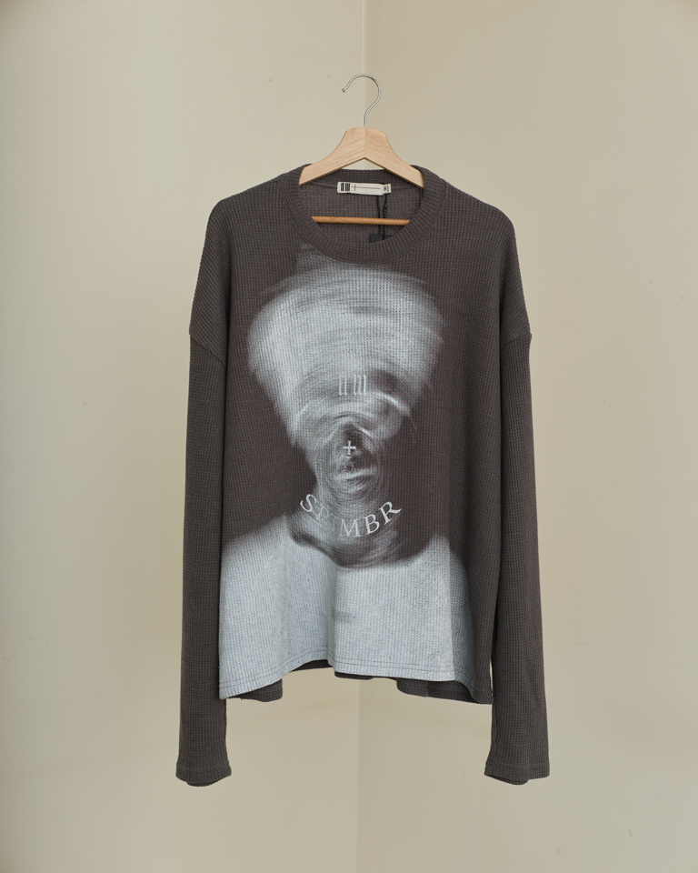 Distorted Reality Graphic Tee featuring a surreal blurred portrait print on textured waffle knit fabric with a relaxed oversized silhouette.