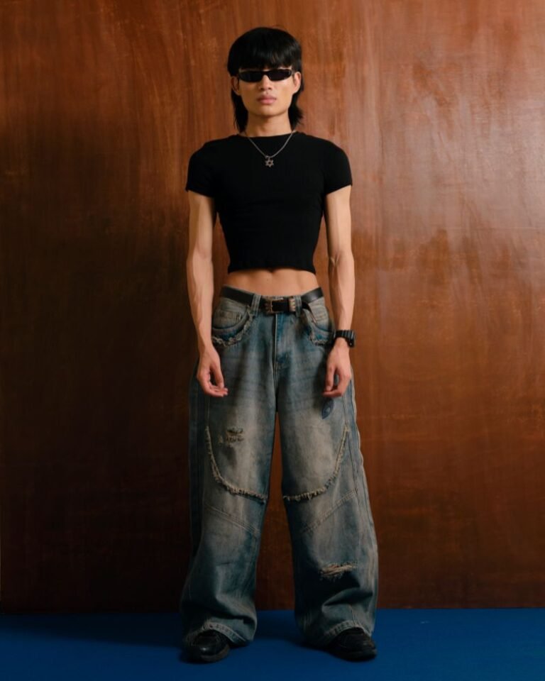 Washed blue baggy denim jeans with curved front panel detailing and distressed accents