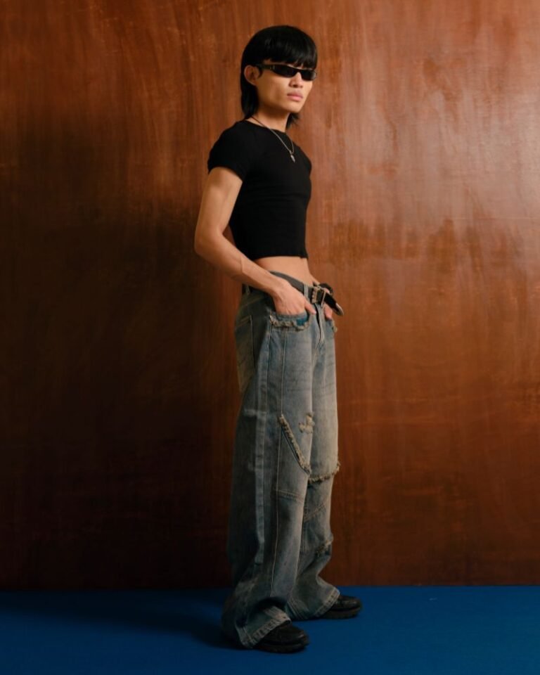 Washed blue baggy denim jeans with curved front panel detailing and distressed accents