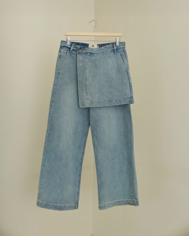 Light blue wide-leg denim jeans with integrated skirt overlay and adjustable button waist