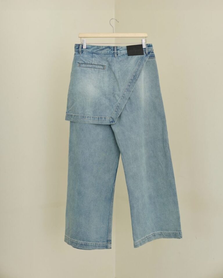Light blue wide-leg denim jeans with integrated skirt overlay and adjustable button waist