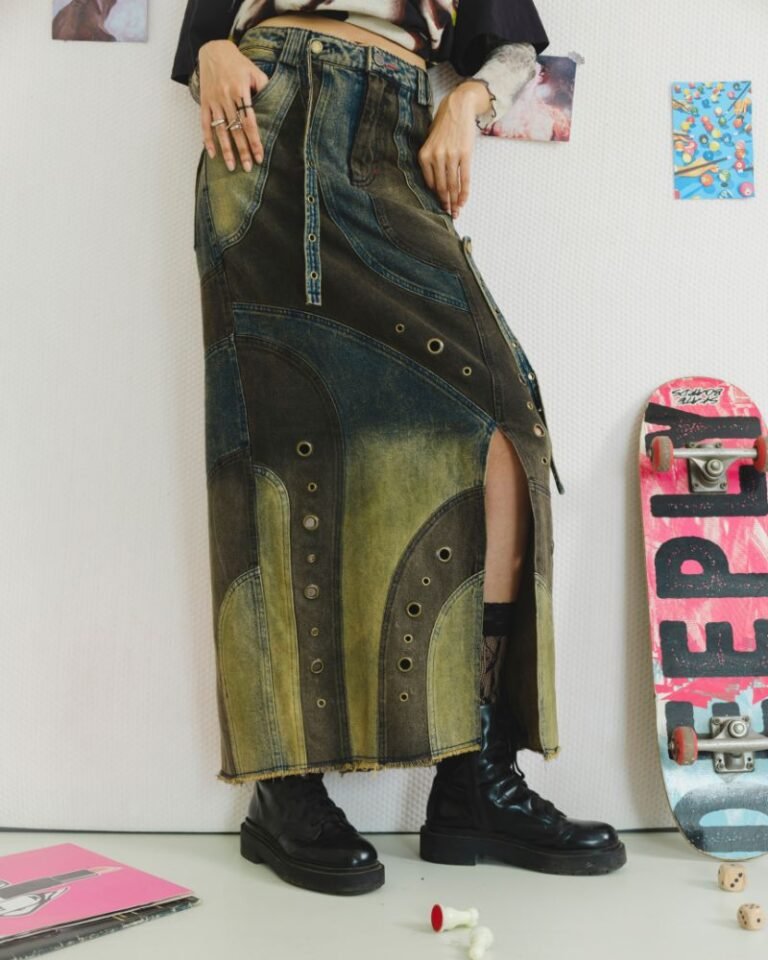 Upcycled blue and dark denim skirt with curved panels, metal grommets and raw hem