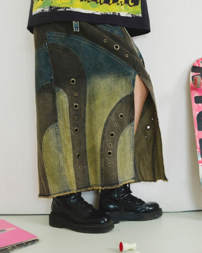 Upcycled blue and dark denim skirt with curved panels, metal grommets and raw hem