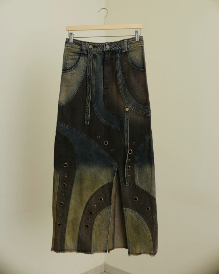 Upcycled blue and dark denim skirt with curved panels, metal grommets and raw hem