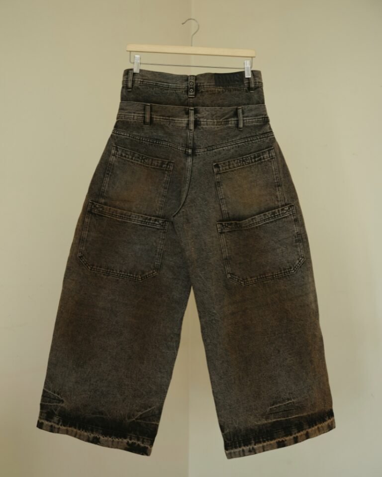 Brown and black acid mud-wash wide-leg jeans with a layered double waistband and double back pockets, shown on a hanger front and back.